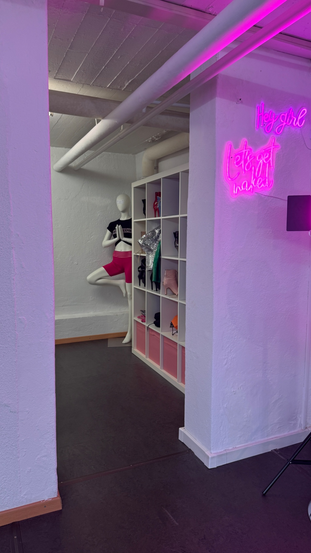 Wardrobe area with heels and neon signage